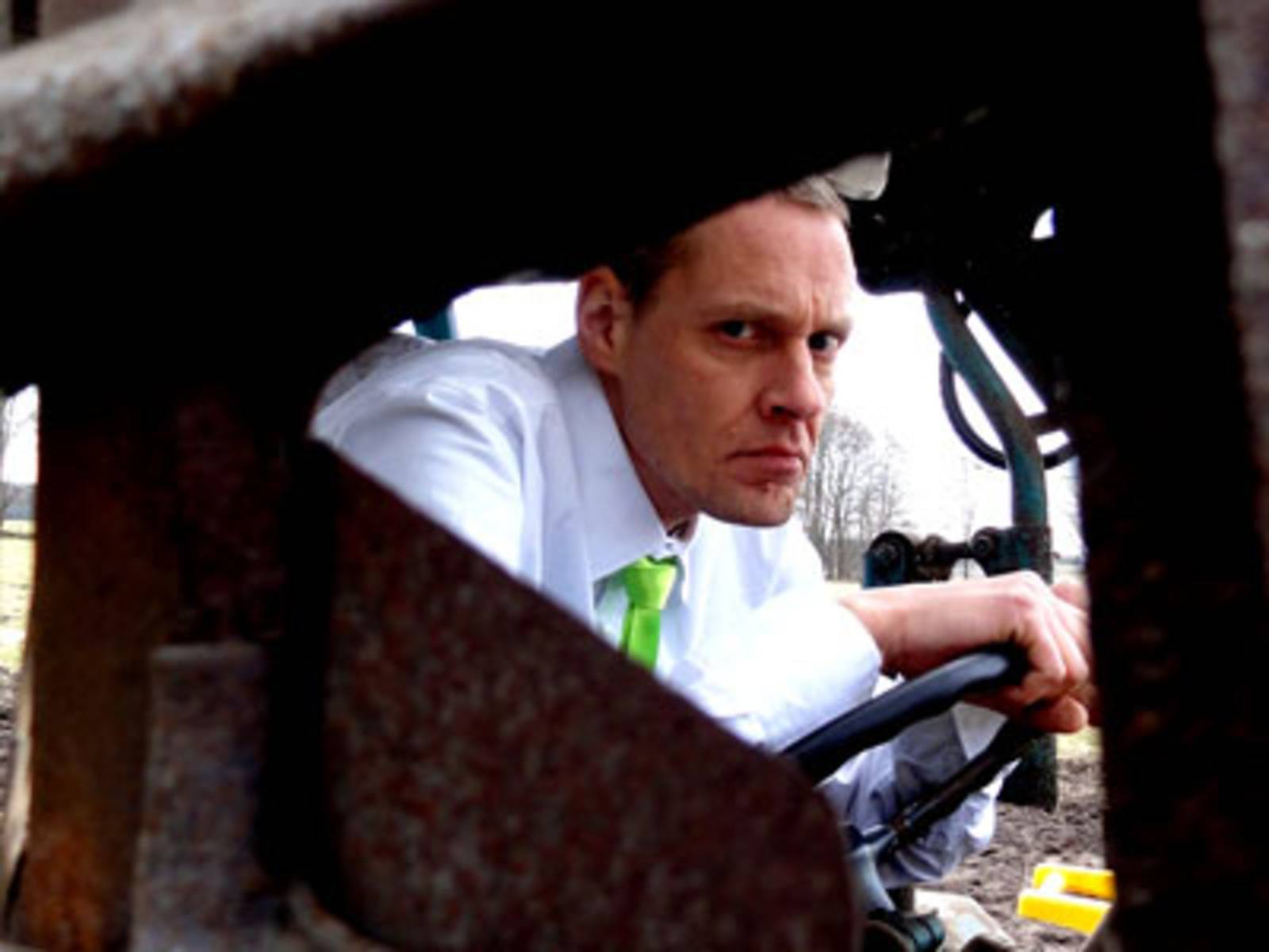 Eine böse schauender Mann sitzt auf einem landwirtschaftlichen Fahrzeug.