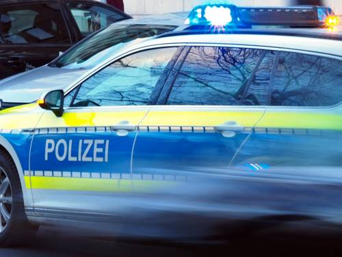 Ein Einsatzwagen der Polizei ist mit eingeschaltetem Blaulicht auf einer Straße.