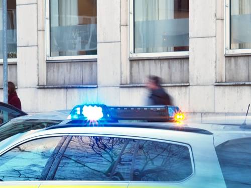 Ein Einsatzwagen ist mit eingeschaltetem Blaulicht auf einer Straße.