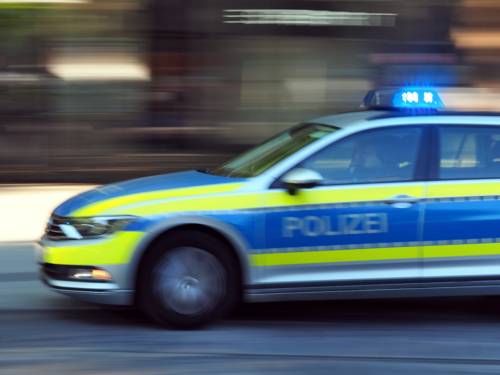 Ein Polizeiauto fährt mit Blaulicht.