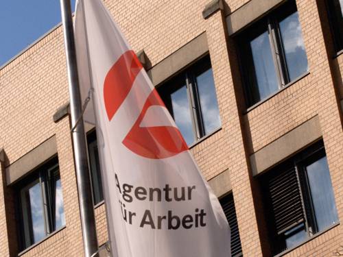 Fahne der Agentur für Arbeit vor Gebäude