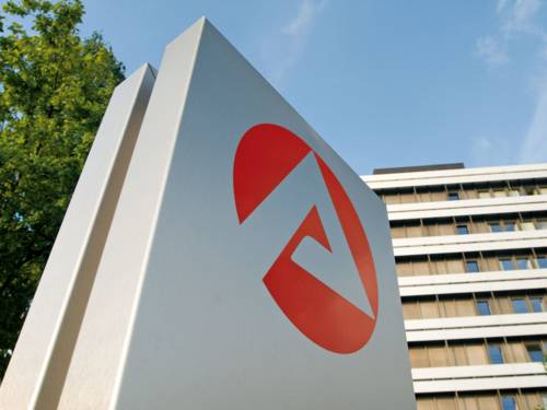 Logo der Bundesagentur für Arbeit auf einer Säule, im Hintergrund ein großes Gebäude.