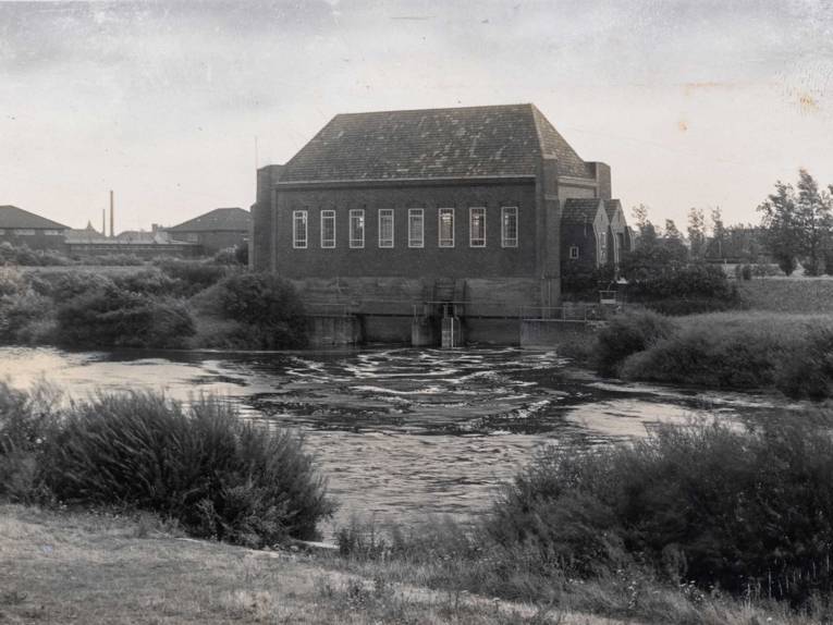 Wasserkraftwerk an einem Fluss gelegen. Historische Schwarz-Weiß-Aufnahme