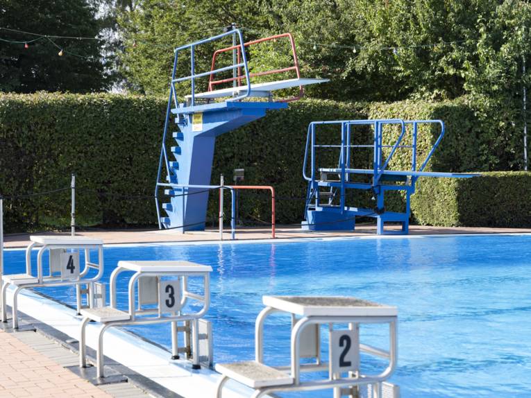 Zwei Sprungtürme am Schwimmbeckenrand, davor Startblöcke