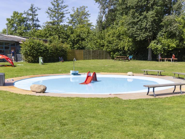 Freibad Goltern - Kinderplanschbecken mit Rutsche und Bänken, die um das flache Becken stehen