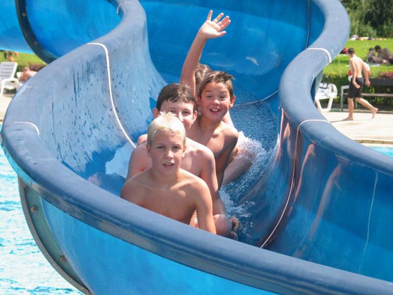 Drei Jungs auf einer kurvigen Wasserrutsche