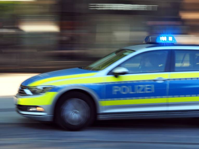Ein Polizeiauto fährt mit Blaulicht.