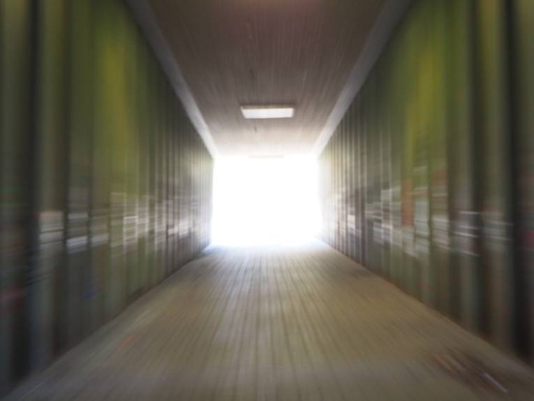 Effekt fliehender Linien zur Mitte durch Reißzoom: Am Ende eines Tunnels strahlt helles Licht.
