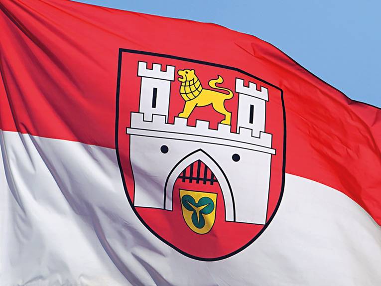 Die Hannover-Flagge mit dem Stadtwappen weht vor blauem Himmel