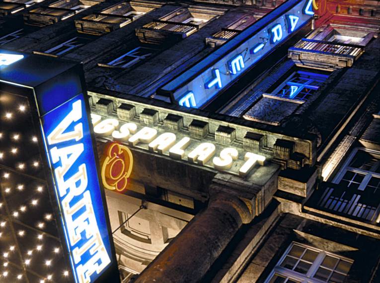 Beleuchtete Fassade des GOP Varieté-Theaters bei Nacht mit leuchtenden Schriftzügen und Neonlichtern an einem historischen Gebäude.