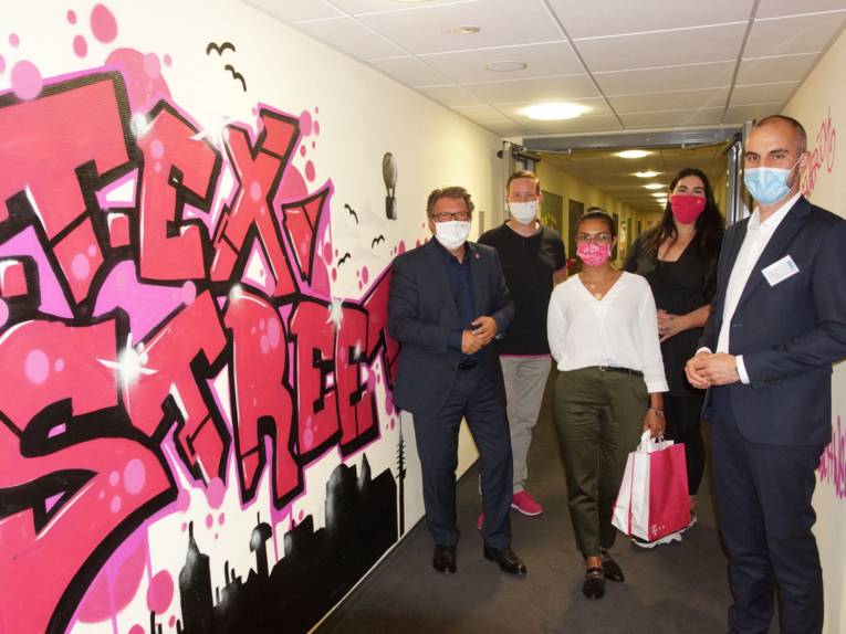 Menschen mit Masken in einem Flur.